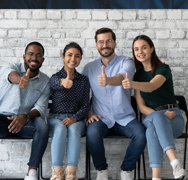 Diverse team of professionals giving thumbs up, representing positive workplace culture and HR support services.